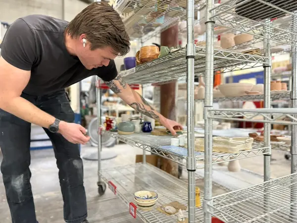 Inspecting Pottery On Studio Drying Racks
