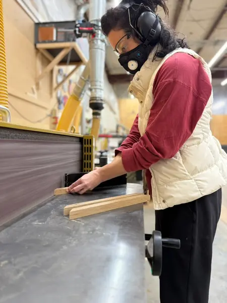 Operator In Respirator At Belt Sander