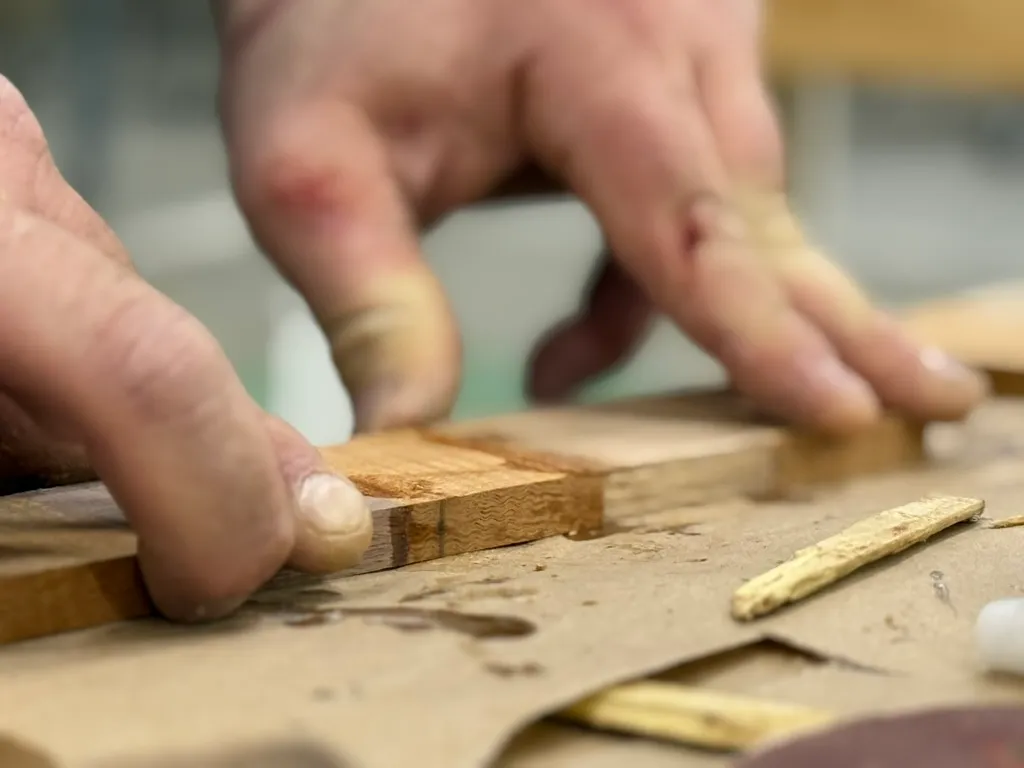 Hands Aligning Wood Strips For Inlay